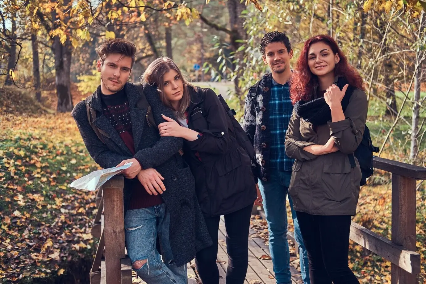 Konzept zu Reisen, Wandern und Abenteuer. Eine Gruppe junger Freunde wandert in einem herbstlich bunten Wald.